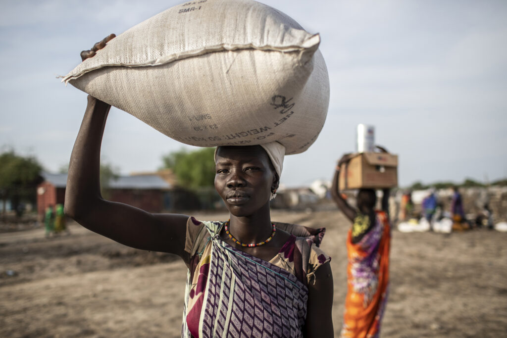 Kvinne bærer sekk med ris på hodet i Sør-Sudan