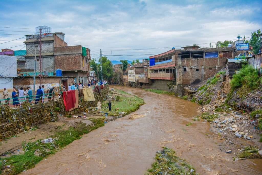 Flomvann renner gjennom en landsby i Pakistan. 