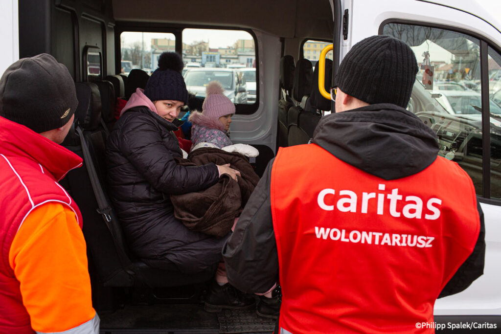 Kvinnelig ukrainsk flyktning og barna får transport til et trygt sted å sove etter å ha krysset den polske grensen.