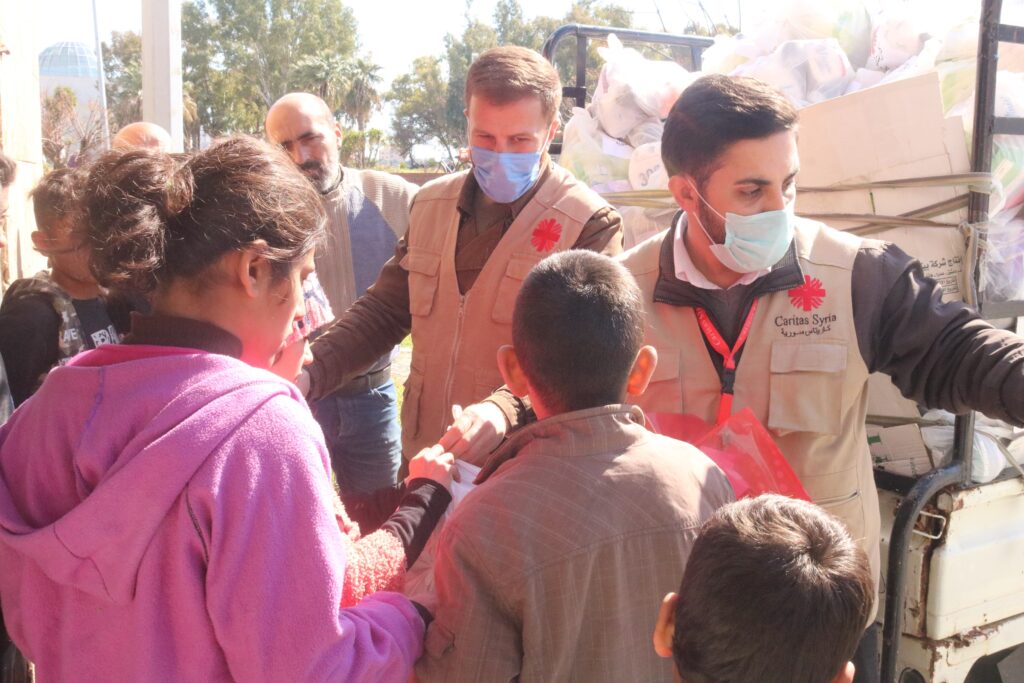 To hjelpearbeidere fra Caritas Syria deler ut nødhjelp til jordskjelvrammede