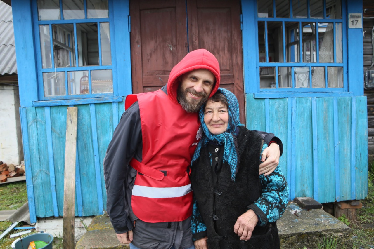 Dyrektor Vyacheslav Grynevych z Caritas Spes trzyma starszą kobietę we wschodniej Ukrainie.
