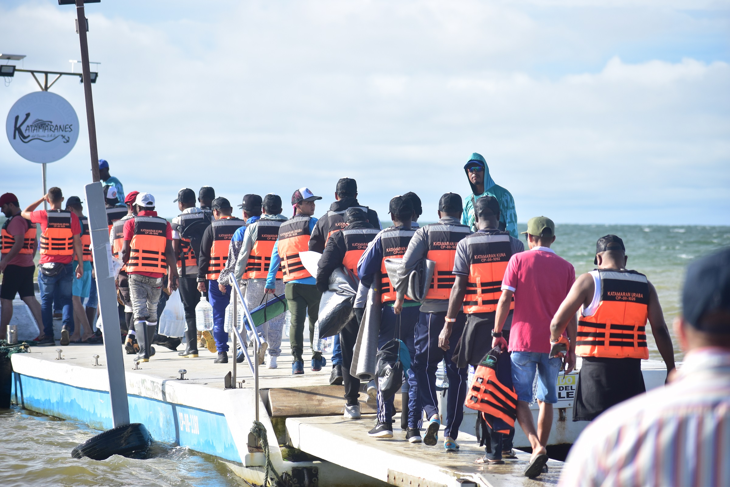 Migranter i kø for å entre en båt som skal ta de videre over Uraba-gulfen i grenseområdet mellom Colombia og Panama.