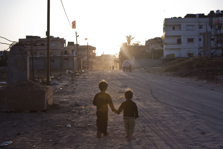 Dwoje małych dzieci spacerujących o zachodzie słońca
