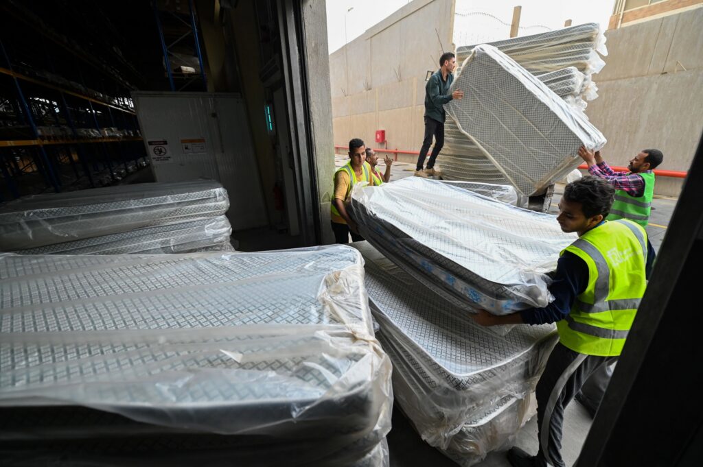 Hjelpearbeidere lemper madrasser som skal til Gaza