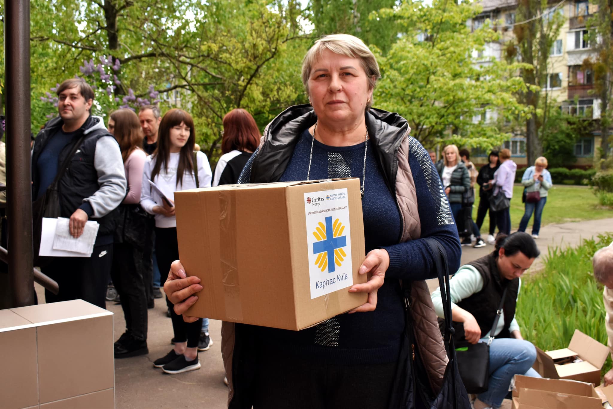 Una mujer en la región de Donetsk recoge un paquete de ayuda de emergencia patrocinado, entre otros, por Caritas Noruega y las autoridades noruegas primavera de 2023. Foto: Caritas Ucrania