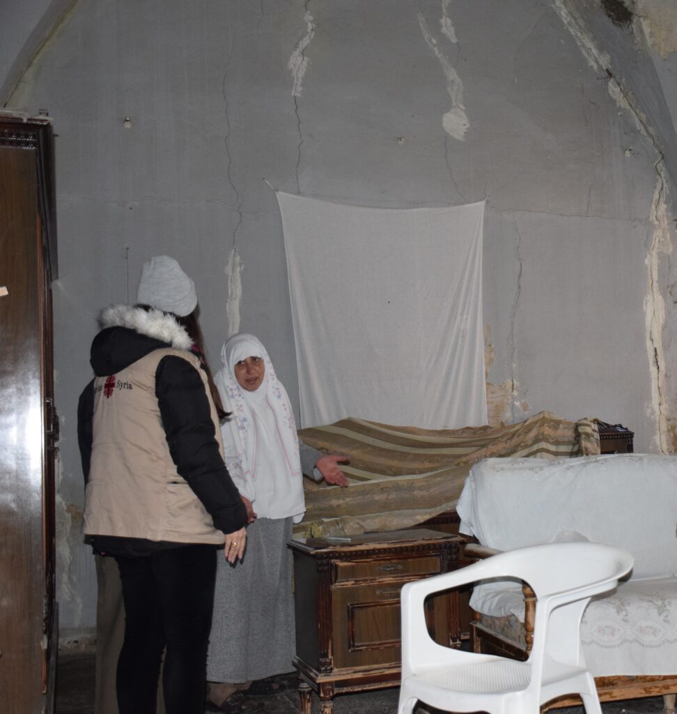 En Caritas-ansatt i Syria snakker med en kvinne som får hjelp til gjenoppbygging av hjemmet. 