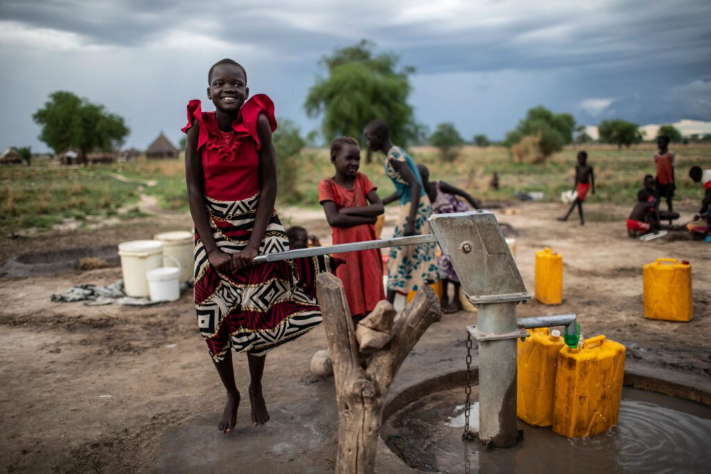 Sør-Sudan: Ung jente pumper etter vann i en brønn 