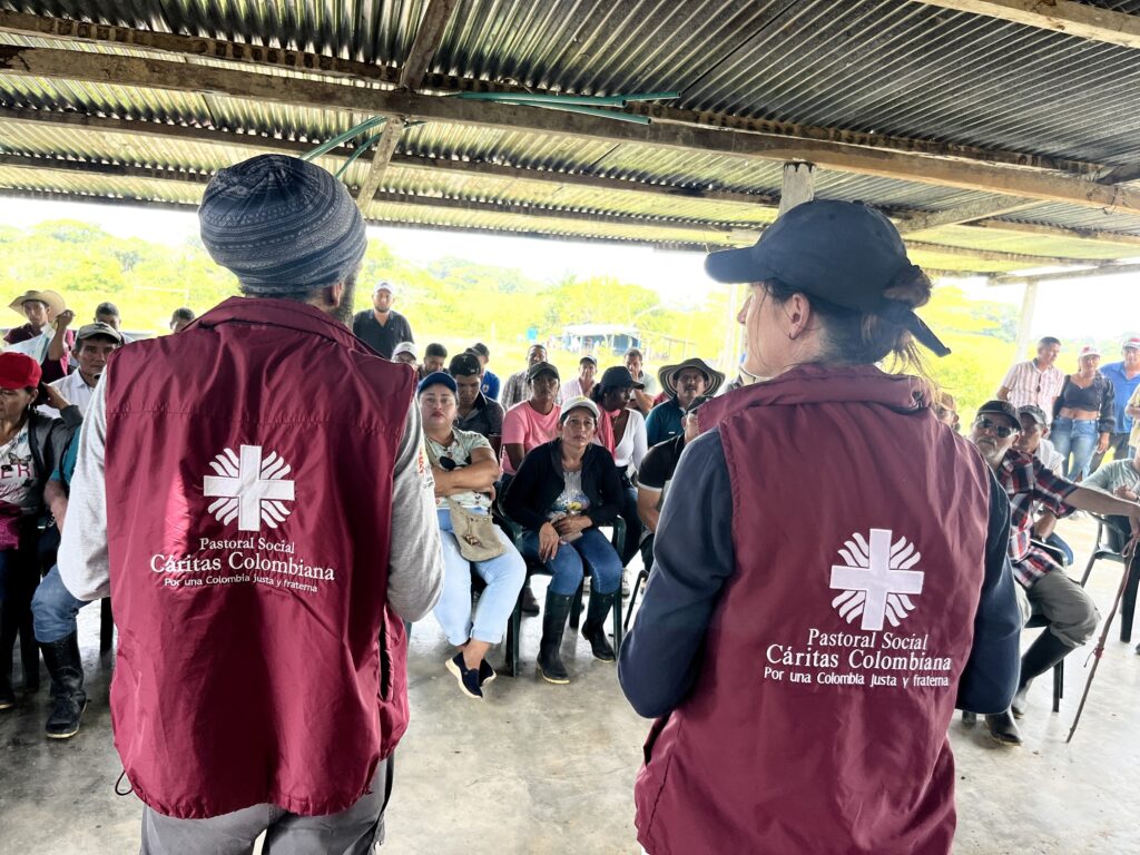 To representanter fra Caritas i møte med befolkningen fra et lokalsamfunn i et skogbevaringsprosjekt i Colombia