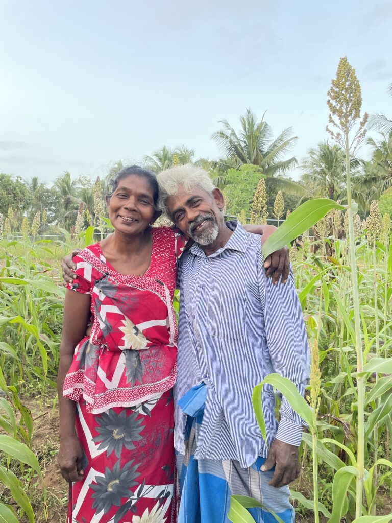 Et ektepar på Sri Lanka står i sin kjøkkenhage. DE er deltagere i Caritas sitt matsikkerhetsprosjekt og får opplæring i klimatilpasset landbruk.