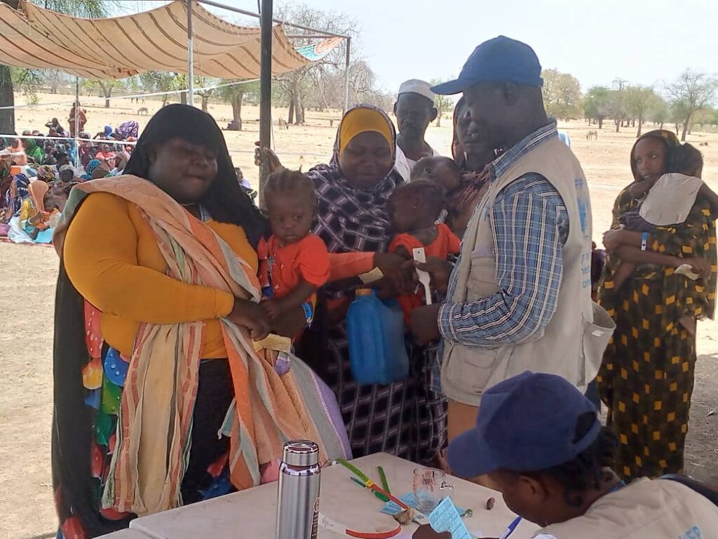 Kvinnelige flyktninger fra Sudan får informasjon fra mannlig representant fra Caritas Mongo på grensen til Chad. 