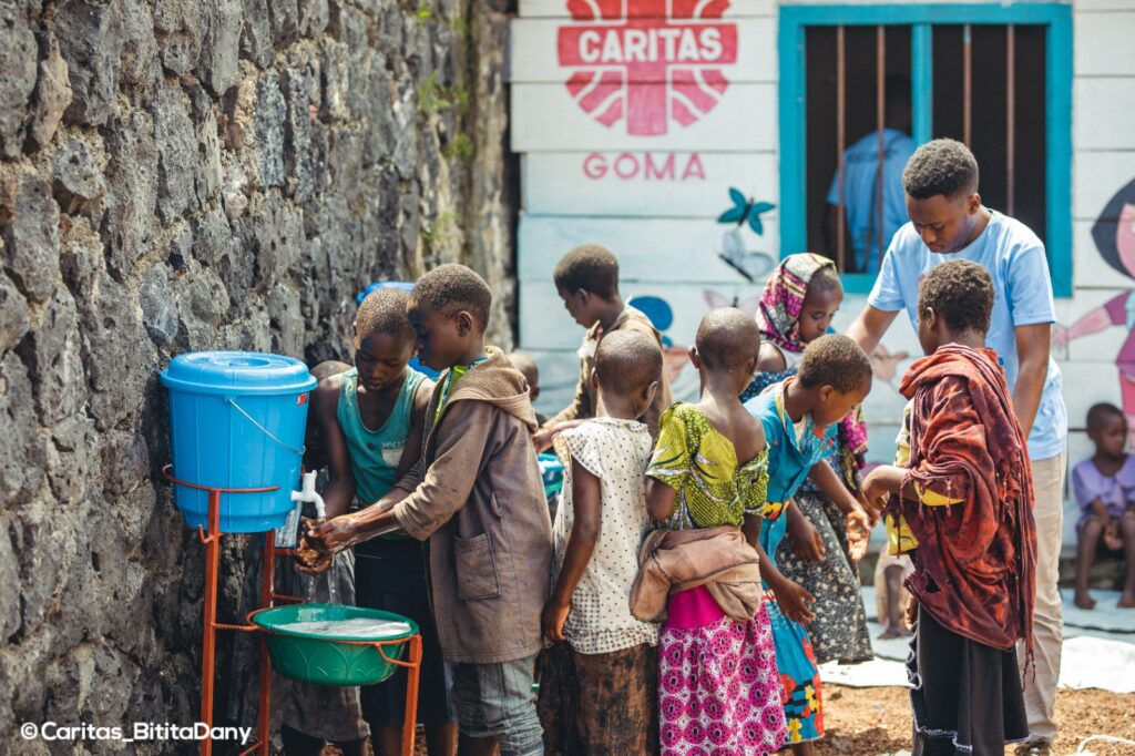 Internt fordrevne barn vasker hendene utenfor lokale til Caritas Goma