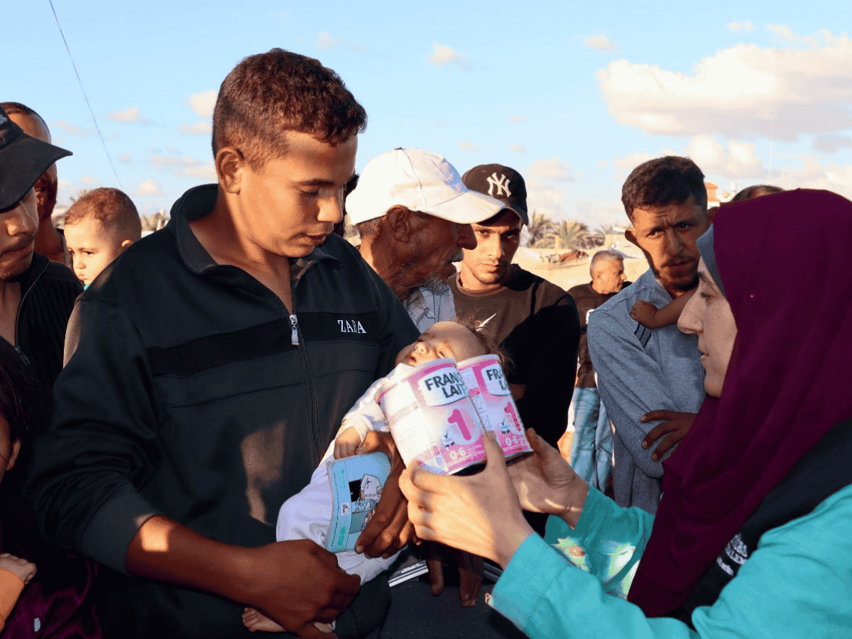 Far med baby i forbindelse med at Caritas deler ut morsmelkerstatning i Gaza