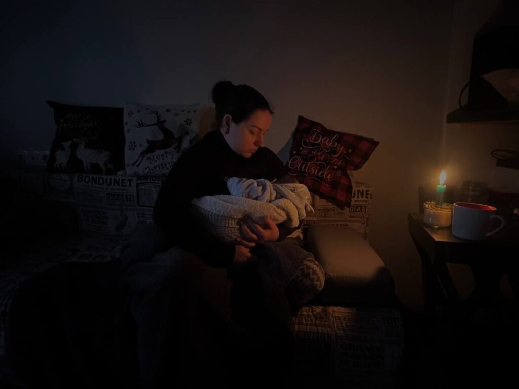 Mariana Matlo i Caritas Spes Ukraine og hennes tre måneder gamle baby i deres mørklagte og kalde leilighet i Kyiv.