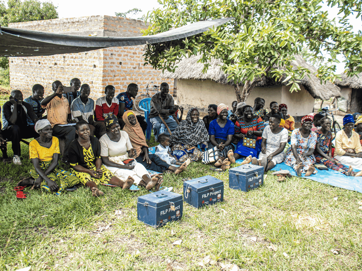 Medlemmer av Oyam Village Paroi Anyim er samlet for å dele erfaringer om kjøkkenhager og annet da Caritas Uganda besøkte dem.