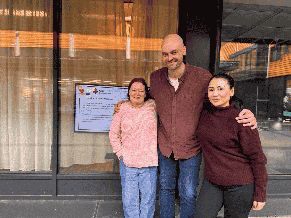 Mona, Daniel og Fuzia ved inngangen til Åpen Dør, Caritas Norges veiledningssenter på Søndre Nordstrand